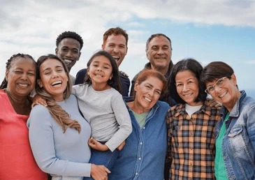 Three generations of a smiling family gathered together outdoors